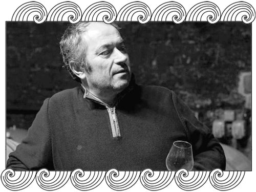 Bruno Schueller, Alsace winemaker, tasting wine in his cellar, framed with Dynamic Cellars wave design