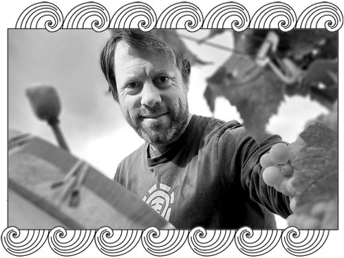 Benoît Marguet, Champagne biodynamic winemaker, inspecting grapes in the vineyard, framed with Dynamic Cellars wave design