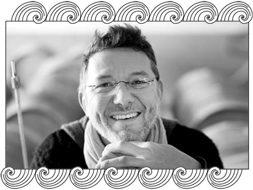Mouzon-Leroux winemaker in his Montagne de Reims barrel room, framed with Dynamic Cellars wave design