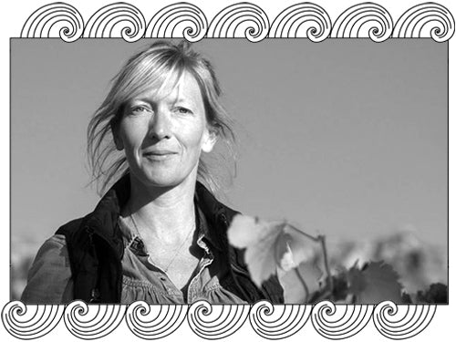 Château de Béru winemaker among her Chablis vines under an open sky, framed with Dynamic Cellars wave design
