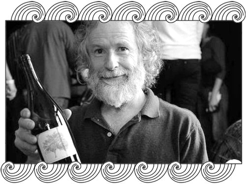 Clos Saron winemaker holding a bottle from the Sierra Nevada foothills, framed with Dynamic Cellars wave design