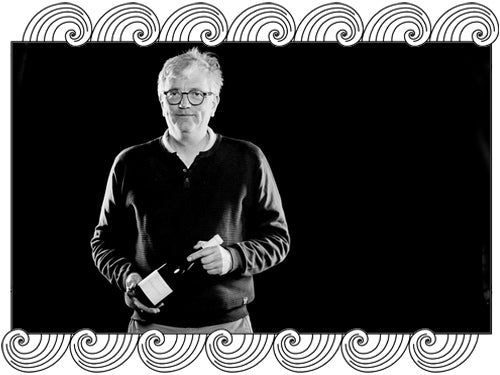 Jean-Yves Bizot, Côte de Nuits winemaker, holding one of his bottles, framed with Dynamic Cellars wave design