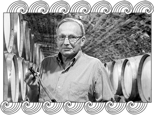 Bruno Clair, Côte de Nuits winemaker, holding a wine thief in his barrel cellar, framed with Dynamic Cellars wave design
