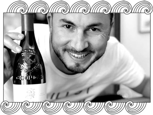 Domaine des Bosquets, Gigondas winemaker, holding a bottle of his estate wine, framed with Dynamic Cellars wave design