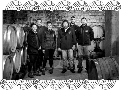 Domaine Ramonet team in their Chassagne-Montrachet barrel cellar, framed with Dynamic Cellars wave design