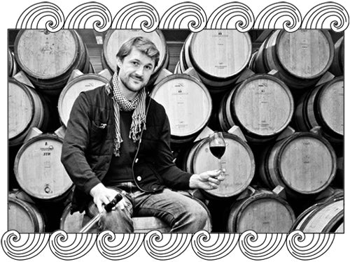Stéphane Ogier, Côte-Rôtie winemaker, tasting wine in his barrel cellar, framed with Dynamic Cellars wave design