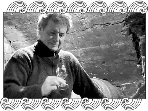 Hervé Souhaut tasting wine in his Ardèche cellar, natural winemaker, framed with Dynamic Cellars wave design