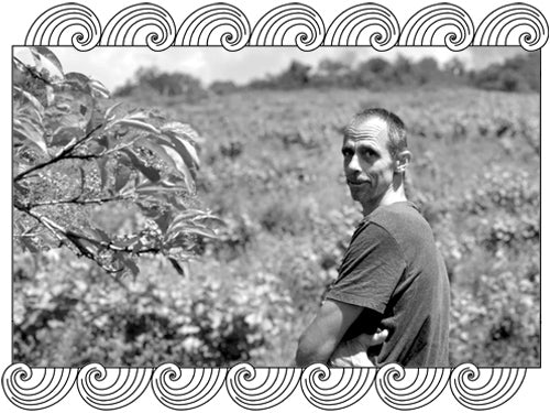 Mythopia winemaker among his natural wine vineyard, arms crossed, framed with Dynamic Cellars wave design
