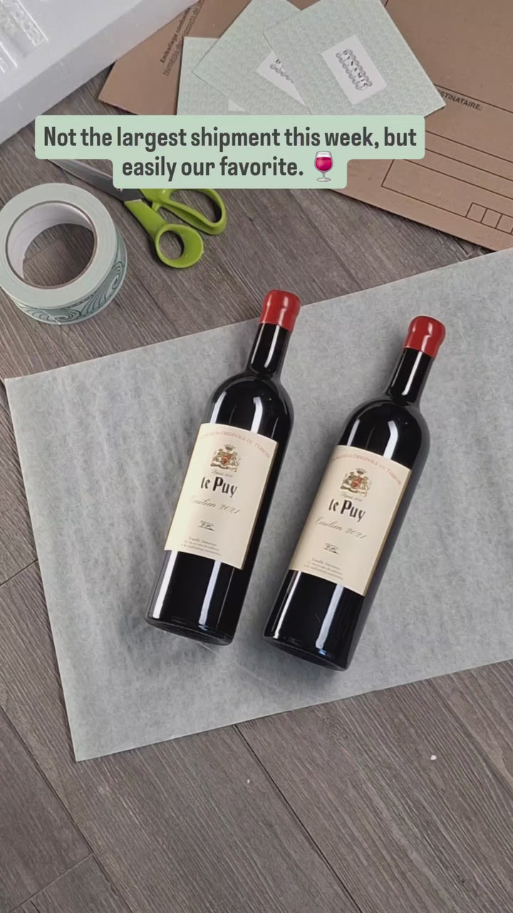 Hand-packing two bottles of Château Le Puy for shipping to Belgrade