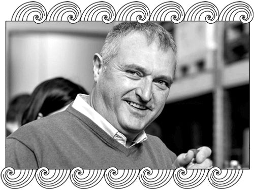 Ton Rimbau Porcellanic, Catalonia winemaker, holding a bottle in his cellar, framed with Dynamic Cellars wave design